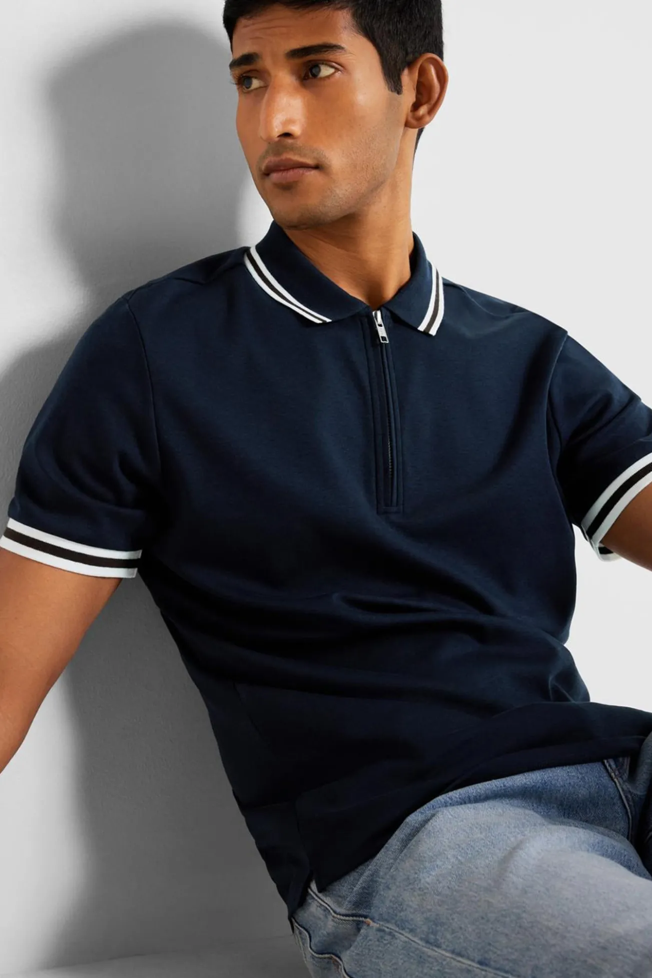 Polo de manga curta com fecho de correr, fabricado em algodão reciclado.