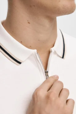 Polo de manga curta com fecho de correr, fabricado em algodão reciclado.